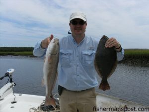 Fred Monroe with a 24" red drum and a 20" flounder caught near Oak Island while fishing with Capt. Brandon Dean with Southport Angler Outfitters.