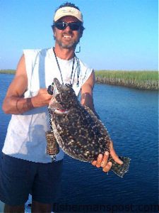 Capt. Mike Pedersen, of No Excuses Charters out of Wrightsville Beach, with a flounder caught on a Gulp bait on an oyster bar in a creek near Topsail Inlet.