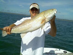 Capt. Tommy Lewis with an over-the-slot red drum caught and released at John's Creek using live bait.