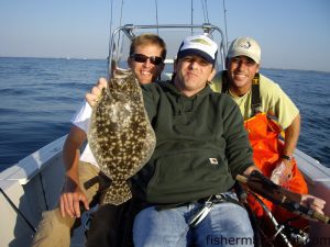 Brandon Matthews, from Southport, with a flounder caught on live bait during the Douglas Cutting bachelor party. He's pictured with Douglas Cutting (left) and Greer Hughes.