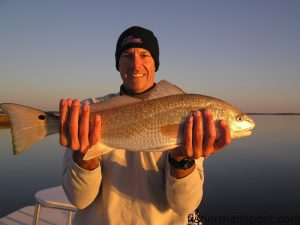 Lee Padrick, from Greenville, NC, with a 26.5” red drum that fell for a bone-colored MirrOlure She Dog in a marsh near Morehead City. Photo courtesy of Dwayne Smith. 