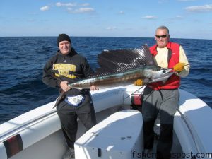 Casey Bough (left), from Wilmington, caught and released this 61” sailfish near the Nipple while fishing with Capt. Mike Jackson (right) of Live Line Charters. The sailfish fell for a swimming plug. 