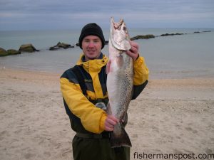 Josh Spangler, of Charlotte, with an 8.18 lb. speckled trout he hooked in the surf at the Cape Lookout jetty at daybreak while fishing with his father. The big speck fell for an 808 MirrOlure.