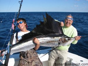 Jackson David and his father Phillip with one of three sailfish they caught and released near the Same Ol' on pink/white Ilanders aboard the "Hoo's Ya Daddy."