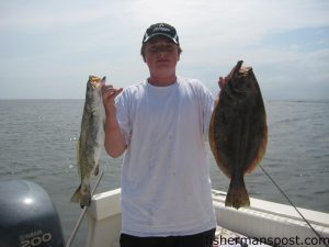 Blake Leigh, of Wilmington, with a flounder and a speckled trout he hooked on live pogies while fishing the Cape Fear River near Southport.
