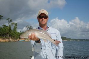 Capt. Rennie Clark, of Tournament Trail Charters, with a slot redfish that fell for a topwater plug in a bay behind Topsail Island.