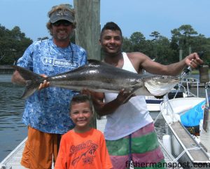 Capt. Mike Pedersen, of No Excuses Charters, and Gage and CC Simspon with a cobia that fell for a live pogy after swimming up to the boat 7 miles off south Topsail.