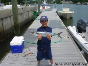 Vance Hardy (age 8) with a spanish mackerel he hooked while fishing with his uncle and grandfather Rob and Bob Tennille.