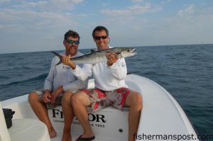 Capt. Charles Brown of Old Core Sound Guide Service looks on as Gary Hurley holds a school king mackerel he hooked at a wreck just off Cape Lookout on a live pogy.
