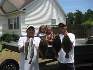 Kenny Sheperd and Ruby, Virginia, and Jamie Fowler with speckled trout and flounder they hooked in the Cape Fear River on Carolina-rigged peanut pogies.