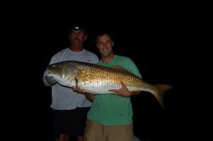 Capt. Charles Brown and Gary Hurley with Hurley's 51" buzzer-beater red drum. The red fell for a hunk of cut mullet at a slight gully in the bottom near Cedar Island.