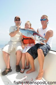Phil and Isabelle Morocco, of Sharon, PA, and Capt. Adam Powell with a wahoo Isabelle hooked on a cigar minnow pinned to a Blue Water Candy Dead Bait Rig. She was fishing at the 200/200 with Capts. Andy and Adam Powell of All In Charters.