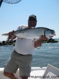 Capt. Mark Dickson, of Shallow Minded Fishing Charters out of Little River, with a 15 lb. tarpon hooked by a client on a live shrimp beneath a float at the Little River Jetties.