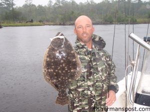 Capt. Ricky Kellum, of Speckled Specialist Charters, with a 23" flounder that fell for a white Trigger-X shrimp in a creek off the New River near Jacksonville.