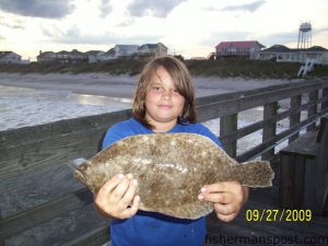 Jaycob, from Hampstead, NC, with a keeper flounder he hooked on a live bait from Surf City Pier.
