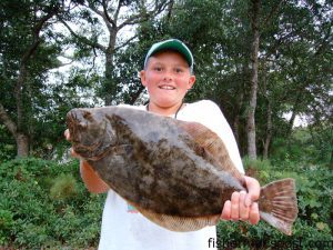 Alec Grooms (age 10), of Southport, with a 6 lb. flounder he hooked on a live finger mullet in the lower Cape Fear River while fishing with his father Eddie.