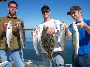 Johnny and Joey Cartwright and Tony Donato with part of a catch of speckled trout and a 3 lb. flounder they hooked on pink Gulp baits in the marsh behind Emerald Isle while fishing with Capt. Rob Koraly of Sandbar Safari Charters.