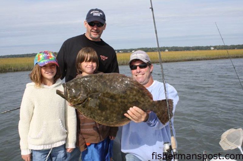 Mark, Sam, and Ryan Cronk, from Smith Mountain Lake, VA, and Capt. Tom Cushman, of Capt. Cush Calmwater Fishing Charters, with an 11 lb., 4 oz. flounder they caught near the Little River jetties on a large finger mullet.