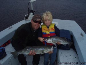 Capt. Travis Dant and Owen Wrenn with the result of a striped bass double hookup. They found the fish busting pogies on the surface in the lower Cape Fear River while fishing with Owen's father, Capt. Danny Wrenn of 96 Charter Company.