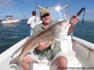Bob Caldwell, from Charlotte, with a big red drum he hooked on a live pogy at the Little River jetties while fishing with Capt. Mark Staci of Shallow Minded Inshore Fishing.