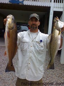 John Mayer, of Oak Island, with a 25" red drum and a 23" speckled trout he hooked while kayak fishing near Wilderness Landing. The red fell for a finger mullet on a jighead, and a 51MR MirrOlure fooled the speck.