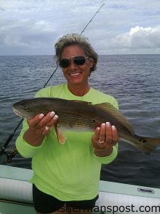 Anne Baum, of Hatteras Village, with a 21" puppy drum she caught and released after it struck a live finger mullet on the Hatteras Inlet flats while she was fishing with her husband Tony.