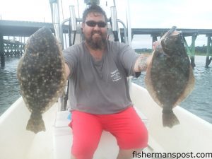 Michael Hobbs, of Chambersburg, PA, with his first pair of flounder, hooked on live finger mullet near a Wrightsville Beach dock while he was fishing with Rob Boline.