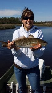 Carrie Lucht with her first red drum, a 20" fish that bit a D.O.A. paddletail soft plastic while she was fishing in Queens Creek with Marcus Denning.