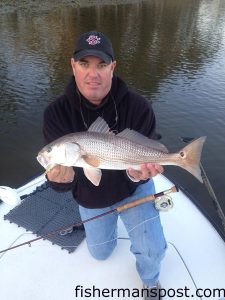 Capt. Mark Dickson, of Shallow Minded Inshore Fishing Charters, with a red drum that struck a Clouser Minnow fly near Sunset Beach.