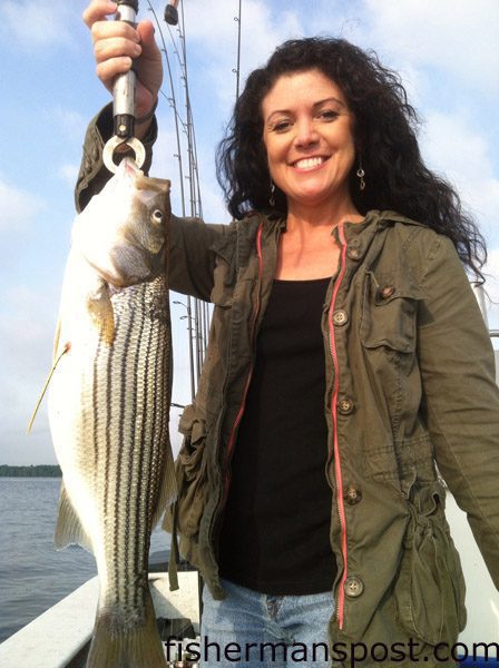 Penny Asby with a tagged striped bass, one of many she hooked on topwater plugs while fishing the Pamlico River with Capt. Mitchell Blake of FishIBX.com.