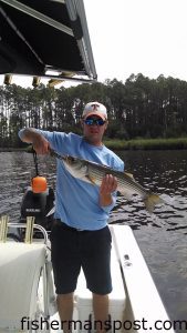 Andrew Pope, of Hugo, NC, with a 25" striped bass that bit a topwater plug in the Neuse River near New Bern.