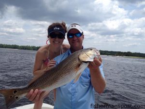 Amy Monsour, of Sanford, NC, with a 27" red drum she caught and released after it struck a live menhaden while she was fishing with Richie Ward near Little River Inlet.