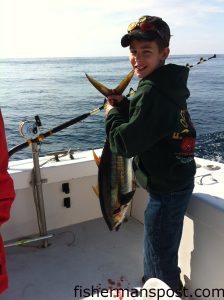 Blake Reynolds with his first yellowfin tuna, hooked on a trolled ballyhoo offshore of Oregon Inlet while he was fishing with his uncle, mate Mikey Fulgham, and Capt. Lee Collins aboard the "Strike'Em" out of Oregon Inlet Fishing Center.