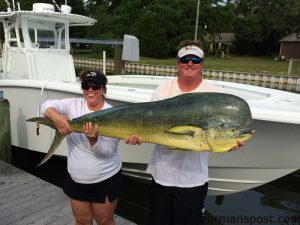 Tracy and Henry Moore with a 46.8 lb. dolphin that Tracy landed after it bit a skirted ballyhoo along a weedline off New River Inlet in 450' of water while they were trolling on the "Bobcat."