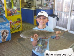 Ethan Jensen (age 7), of South Mills, NC, with a 25" puppy drum that struck a red/white Gotcha plug he was working from Outer Banks Pier while fishing with his father.
