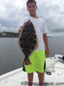 Jake Maguire, of Tabor City, NC, with a 21" flounder that bit a live finger mullet in 15' of water along the Southport waterfront.