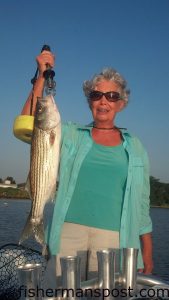 Cora Ogden, of Wake Forest, NC, with a striped bass that she hooked on a topwater plug in the Neuse River near New Bern. She was fishing with her husband and Capt. Ashley King of Keep Castin' Charters.
