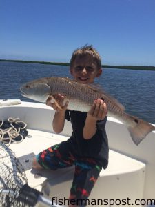 Matthew Slaughter, of Southport, NC, with a slot red drum that bit a live mud minnow near Bald Head Island while he was fishing with family on his ninth birthday.