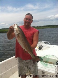 Ken Cutbush, of Lumberton, NC, with a red drum that struck a live finger mullet along a grass bank near Little River Inlet.