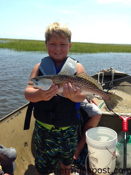 Bryson Mayo with his first speckled trout, an 18″ fish that inhaled a live bait on a Carolina rig near Carolina Beach Inlet.