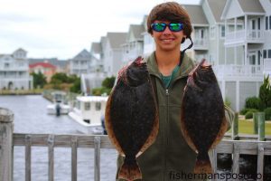 Nolan Minor, of Charlottesville, VA, with 20.5" and 19.5" flounder he hooked in a Pirate's Cove canal. Photo courtesy of TW's Bait and Tackle.