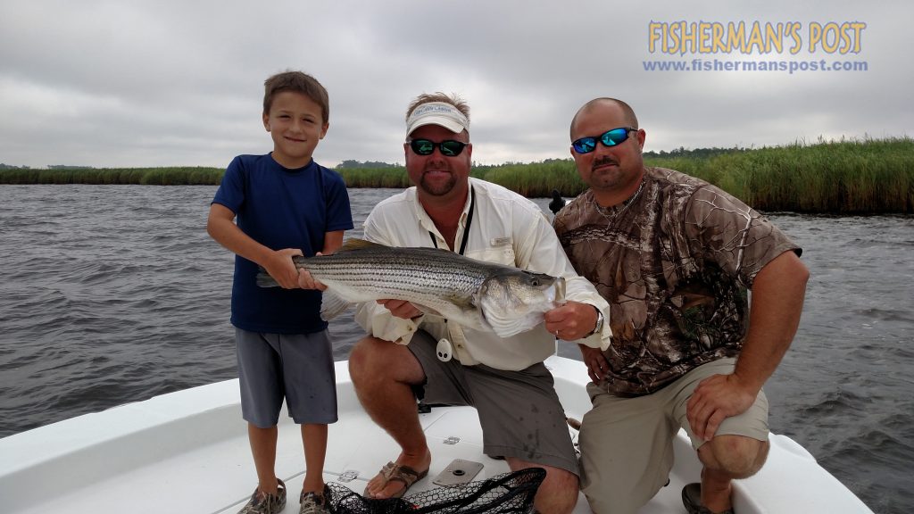 Hunter and Snookie Martin and Capt. D. Ashley King, of Keep Castin' Charters, with a 30.5" striped bass that they hooked while casting along a Neuse River shoreline near New Bern.